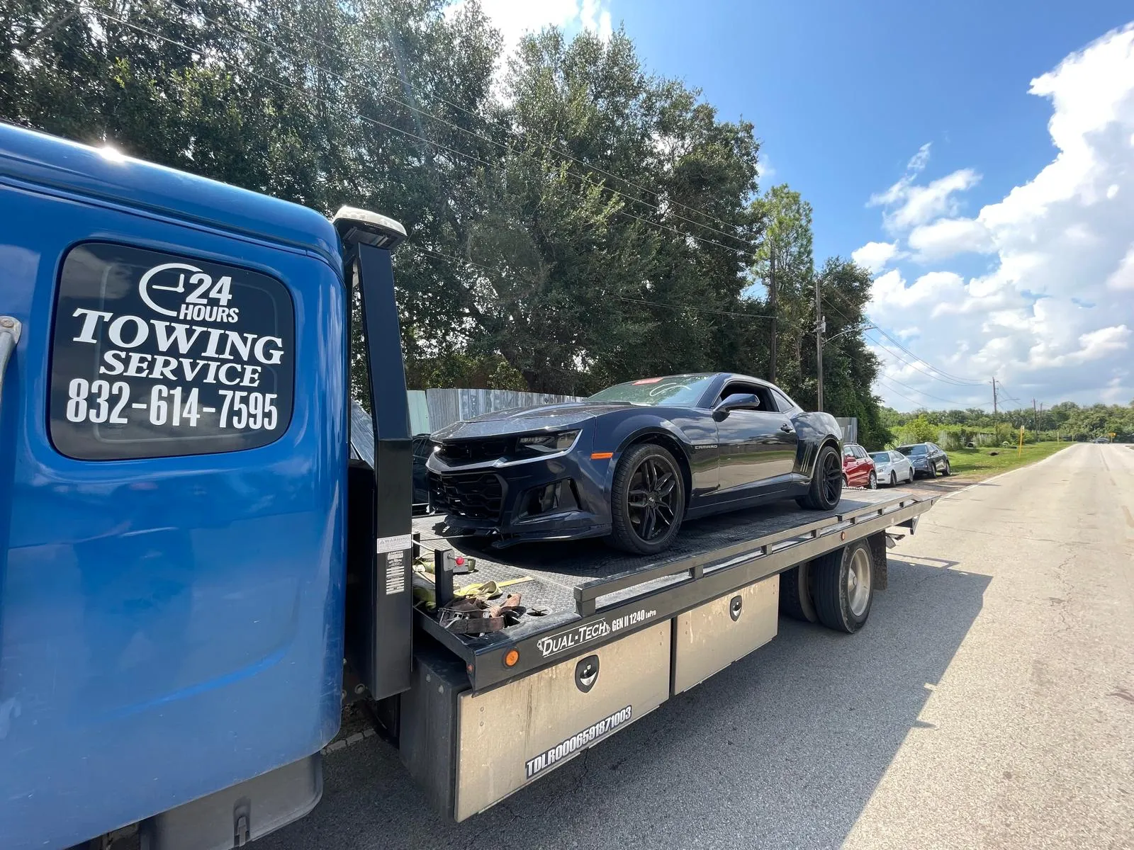 Damaged black Chevrolet Camaro on flatbed after accident in Houston TX