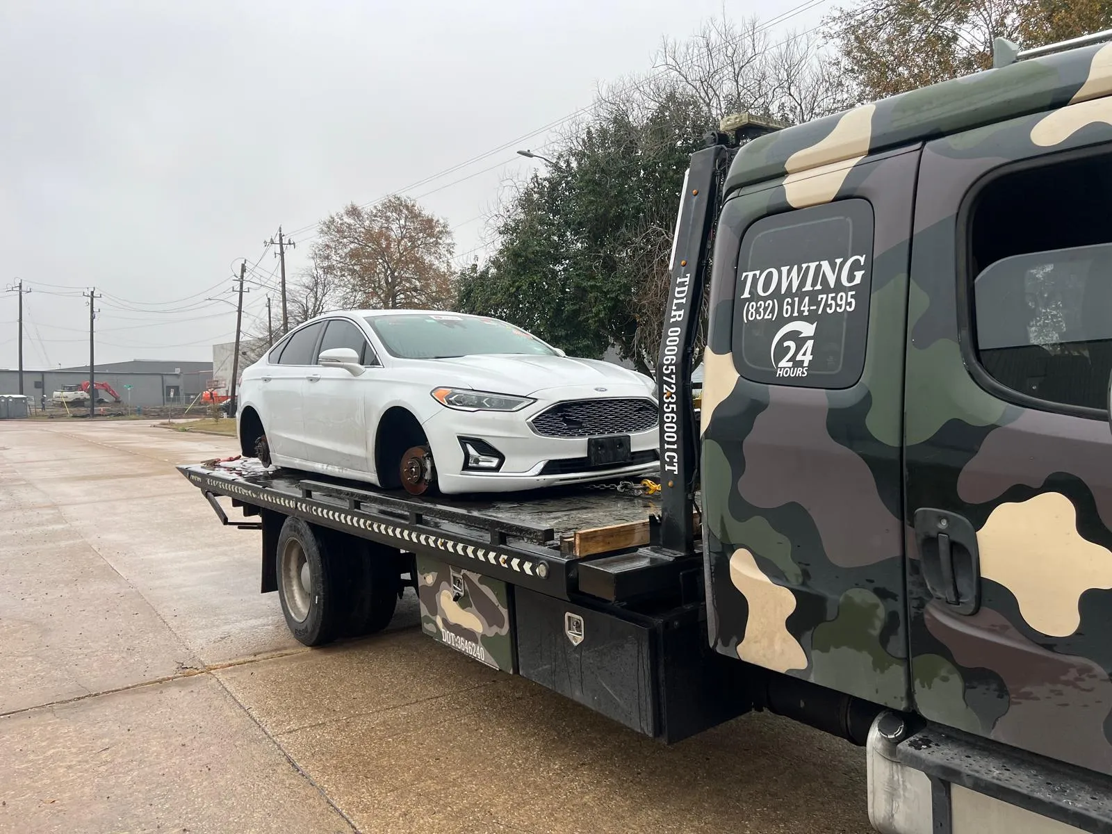 White Ford Fusion on flatbed tow truck in Houston TX