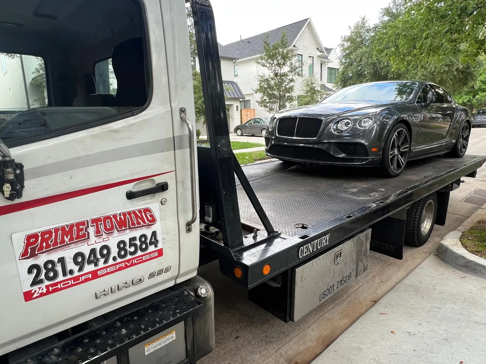 Bentley Continental GT on Prime Towing flatbed truck in Houston TX neighborhood