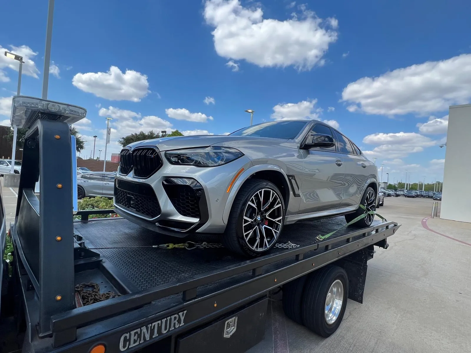 BMW X6M luxury SUV on flatbed tow truck in Houston TX