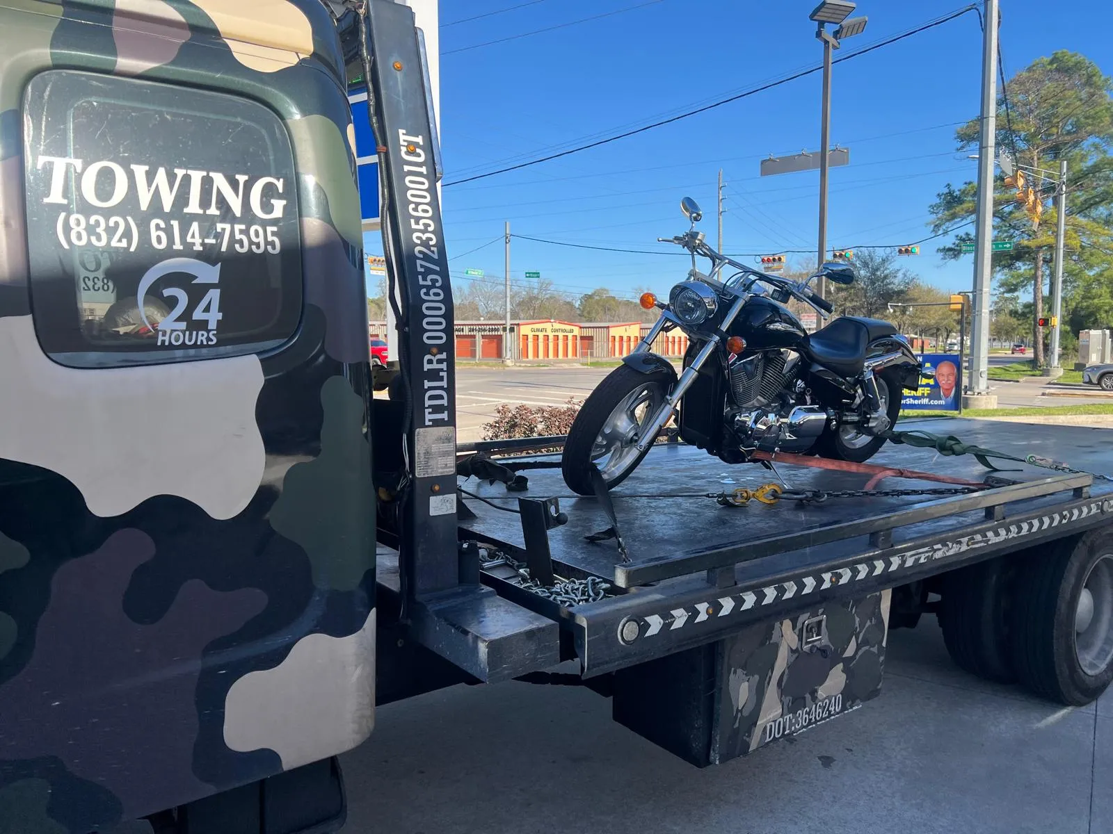 Harley-Davidson motorcycle securely strapped on flatbed tow truck in Houston TX