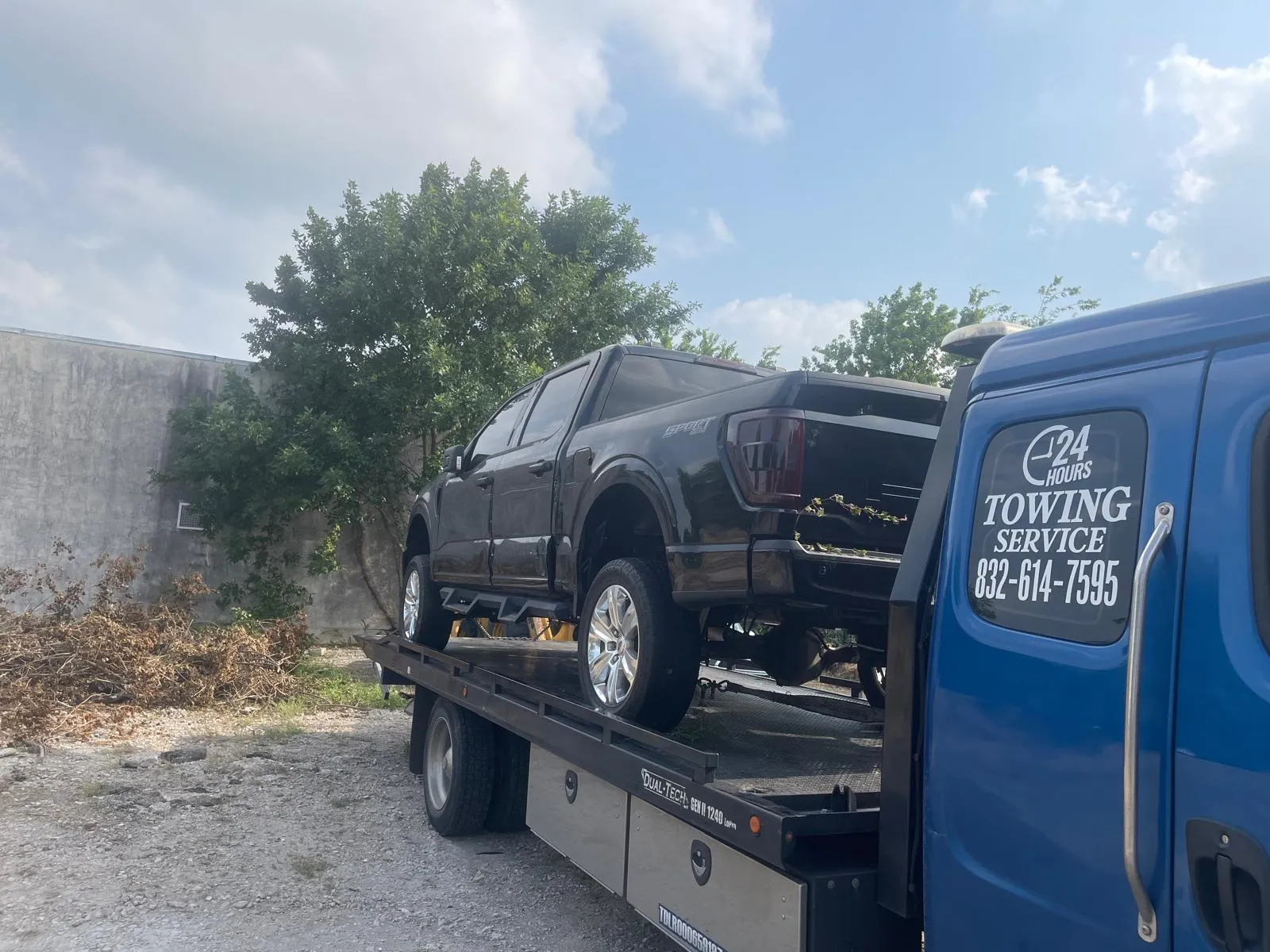 Dark Ford F-250 pickup truck on flatbed tow truck in Houston TX