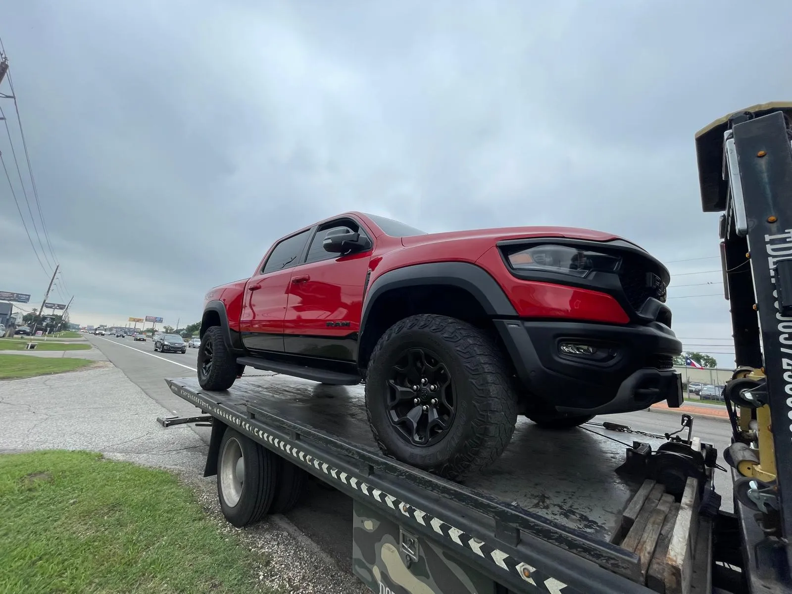 Red RAM TRX on flatbed tow truck on highway in Houston TX