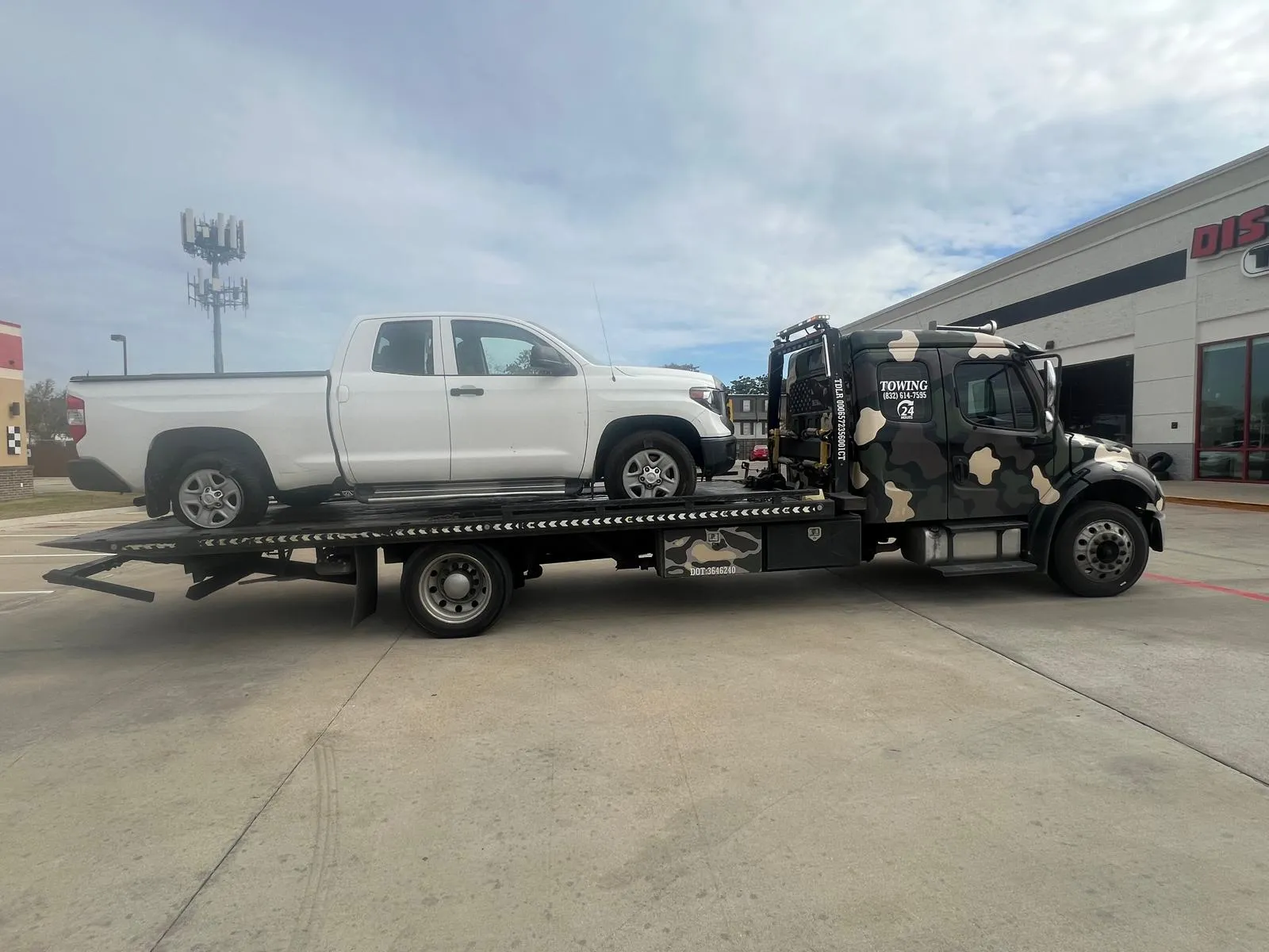 White Toyota Tacoma pickup on flatbed tow truck in Houston TX